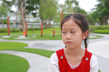 Unhappy with bored face of Asian girl child with looking beside while stay in the garden. - 793793502