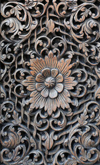 Pattern of flower carved on old wood background. Traditional wooden Thai style.
