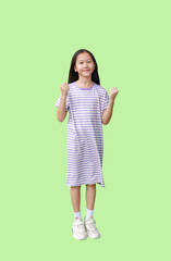Portrait of Asian girl child showing winner raise fists smile gesture isolated on green background. Image full length with Clipping path. - 793794760