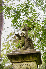Ein Engel schaut zu einem Kreuz hoch auf dem Highgate Cemetery in London Camden