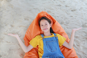 Portrait of happy Asian young girl child in dungarees jean open hands wide or spread your arms and...