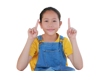 Close-up of Asian girl child in dungarees jean showing two forefingers and looking camera isolated on white background.