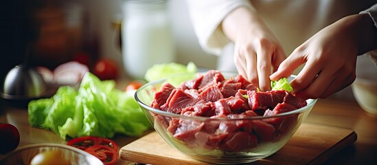 Person adding beef to a dish on a wooden chopping board - obrazy, fototapety, plakaty