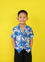 Portrait of Asian boy in summer dress costumes according to Thai culture to celebrate the Songkran festival of people on Thailand New Year on yellow background. - 793797105