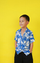 Asian boy in summer dress costumes according to Thai culture to celebrate the Songkran festival of people on Thailand New Year on yellow background. - 793797167
