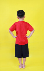 Back view of Asian little boy child stand akimbo posture isolated on yellow background. Image full length. - 793797999