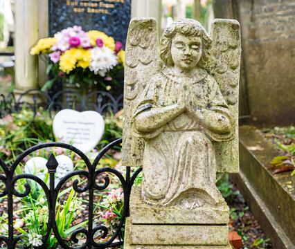 Kniender betender Engel und ein Blumenstrauß auf dem Highgate Cemetery Ostteil Camden, London