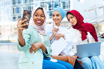 Beautiful muslim girl wearing hijab bonding outdoors