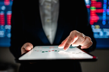 Investors analyze the data stock market index via digital tablet screen to trade the stock chart...