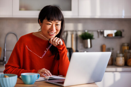 Woman working remotely from home having online meeting - Powered by Adobe
