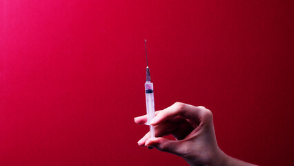 A woman's hand holds a filled medical syringe