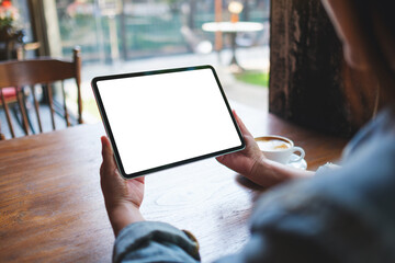 Mockup image of a woman holding digital tablet with blank white desktop screen in cafe - 793812580