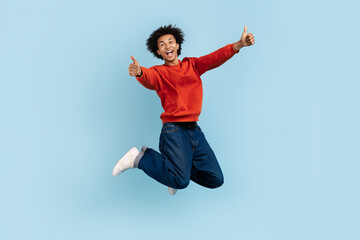 Energetic guy leaping with thumbs up gesture