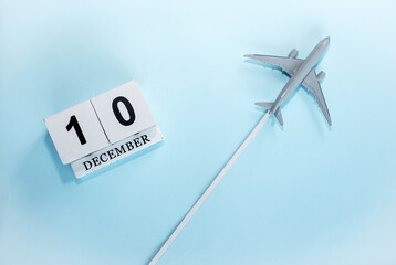 December calendar with number  10. Top view of a calendar with a flying passenger plane. Scheduler. Travel concept. Copy space.