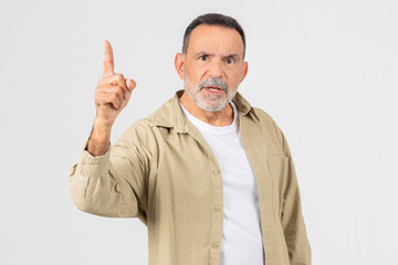 Senior Man Gesturing Upward With Determination Against a White Background