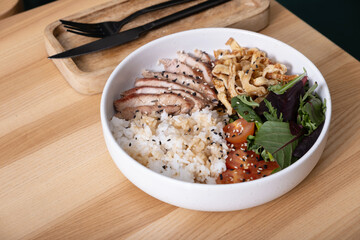 Bowl with rice, veal and vegetables on cafe table. Balanced nutrition concept.