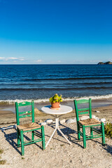 Coffee time, small table with two chairs. Exploring Thasos island with camera, Northern Greece. Autumn perspective of photographer