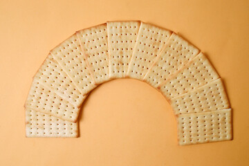 Arrangement of Biscuit Crackers Forming Curve Over Yellow Background