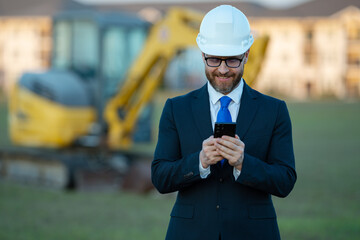 Engineer, construction manager or supervisor at a construction. Supervisor in suit and helmet. Investor, construction manager at a construction. Developer, outdoor portrait . Middle aged architect.