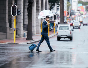 Businessman, walking and city with umbrella on street for travel, work or business trip in winter....
