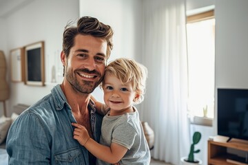 Young smiling father with his baby boy at home