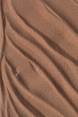 Fototapeta na wymiar Lines drawn in brown sand background, beautiful sand texture, overhead view of chocolate brown sand, zen pattern drawn in the sand, Top view of fine grain texture
