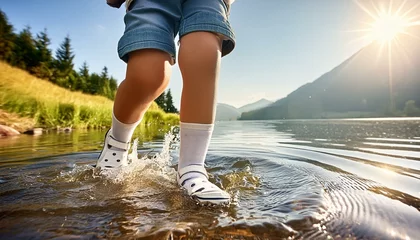 Gartenposter person running in the park, Close-up of kids legs relaxing in lake during hot summer day, top view © Hyder