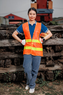 portrait Asian young teen engineer worker standing happy smile outdoor waring safety reflective with hardhat.
