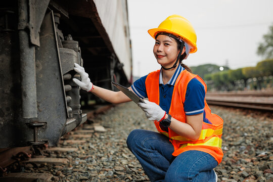 Train locomotive engineer women worker. Young teen Asian working check service maintenance train using tablet computer software.
