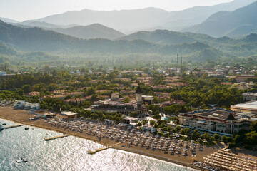 An aerial scenic view of a beach resort in Turkey with majestic mountains on a background