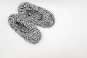 Fluffy gray home slippers isolated on white background. Bed shoes accessory footwear. Top view or flat lay.