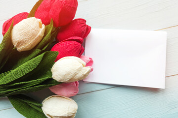 Bouquet of tulips and white mockup blank on wooden background
