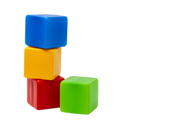 Multicoloured plastic cubes for children's games. The yellow cube stands on top of the red and blue...