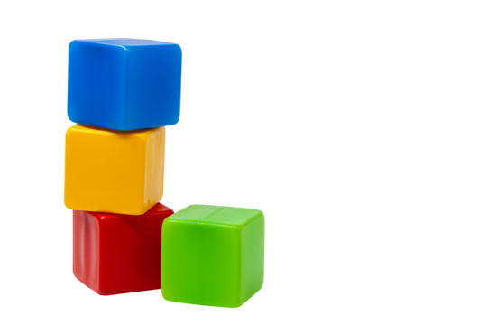 Multicoloured plastic cubes for children's games. The yellow cube stands on top of the red and blue cubes, the green one next to it. Without background