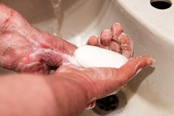 Woman washes her hands with soap under a stream of water. Covid19 concept