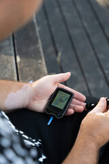 Men checking their sugar levels using a glucometer
