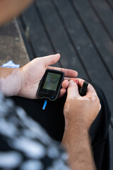 Men checking their sugar levels using a glucometer