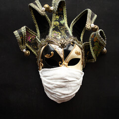 Venice mask in a medical mask on black background. Covid19 concept