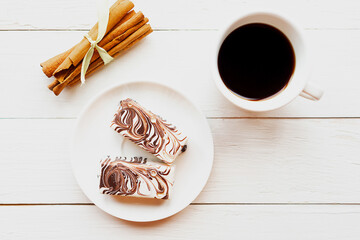 coffee cup and chocolate cakes on wooden table.