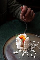 A tantalizing pavlova with vibrant fruit topping, nestled on a rustic plate for a perfect culinary...