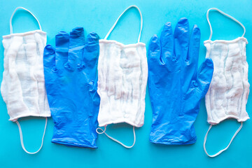 Medical masks and gloves on bright blue background. Coronavirus concept