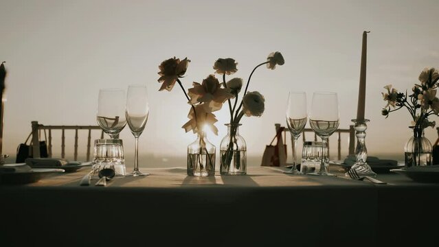 Dinner table decoration flowers candles sunset. Romantic wedding dinner outdoor.