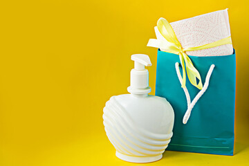 toilet paper roll with gift bow in pocket and liquid soap on bright yellow background