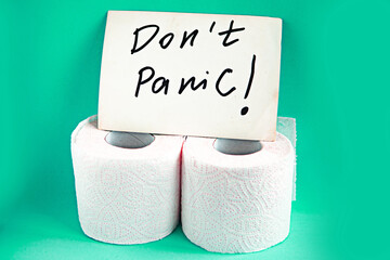 Toilet paper rolls and card with message Don't Panic on blue background. Quarantine concept