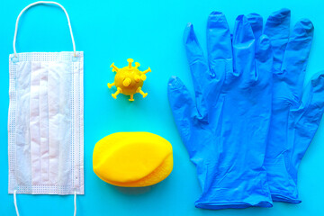 Medical gloves, mask and soap bar on blue background. Covid-19 concept