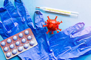 Medical gloves and pills on blue background. Covid-19 concept