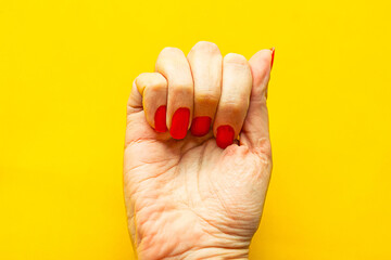 female clenched fist on yellow background