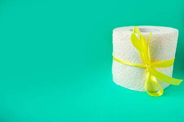 Toilet paper roll in gift bow on bright green background