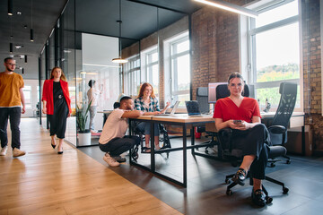 A diverse group of business professionals collaborates in a modern startup coworking center,...