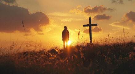 Person standing in front of cross at sunset